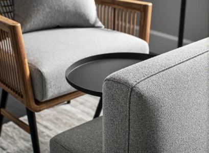 Szary fotel tapicerowany z drewnianym rattanowym oparciem