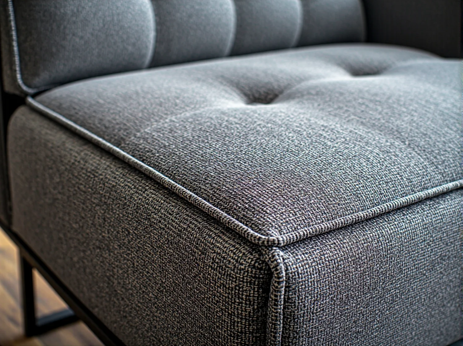 Grafitowa sofa tapicerowana z pikowanym siedziskiem i metalową ramą