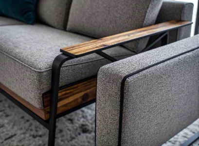 Szara sofa z drewnianymi podłokietnikami i metalową ramą